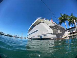 the boat of a hull after a hull cleaning service as seen from the water in a marina in Fort Lauderdale, FL