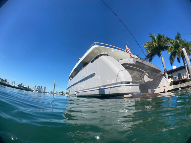 the boat of a hull after a hull cleaning service as seen from the water in a marina in Fort Lauderdale, FL
