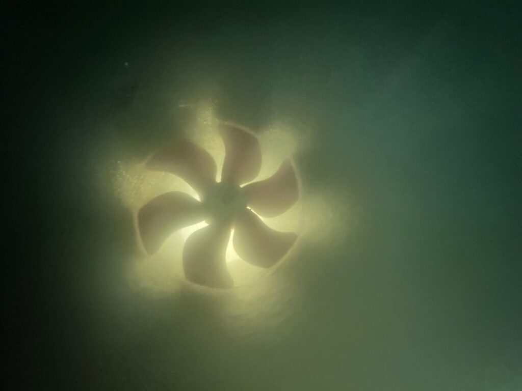 Bow thruster tunnel and propeller photographed underwater during hull cleaning