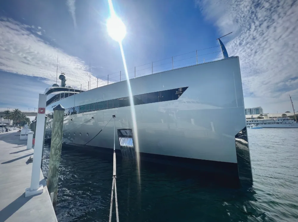 the sun shines brightly on the gleaming hull of a yacht cleaned by the Barnacle King team